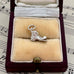 Silver vintage old boot charm in a jewellery box on sheet music background