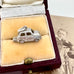 Silver car charm in a jewelry box with an old photograph in the background