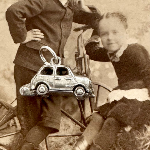 Vintage silver mini charm on an antique photo of children