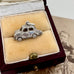 Silver car charm in a jewelry box with an old photograph in the background