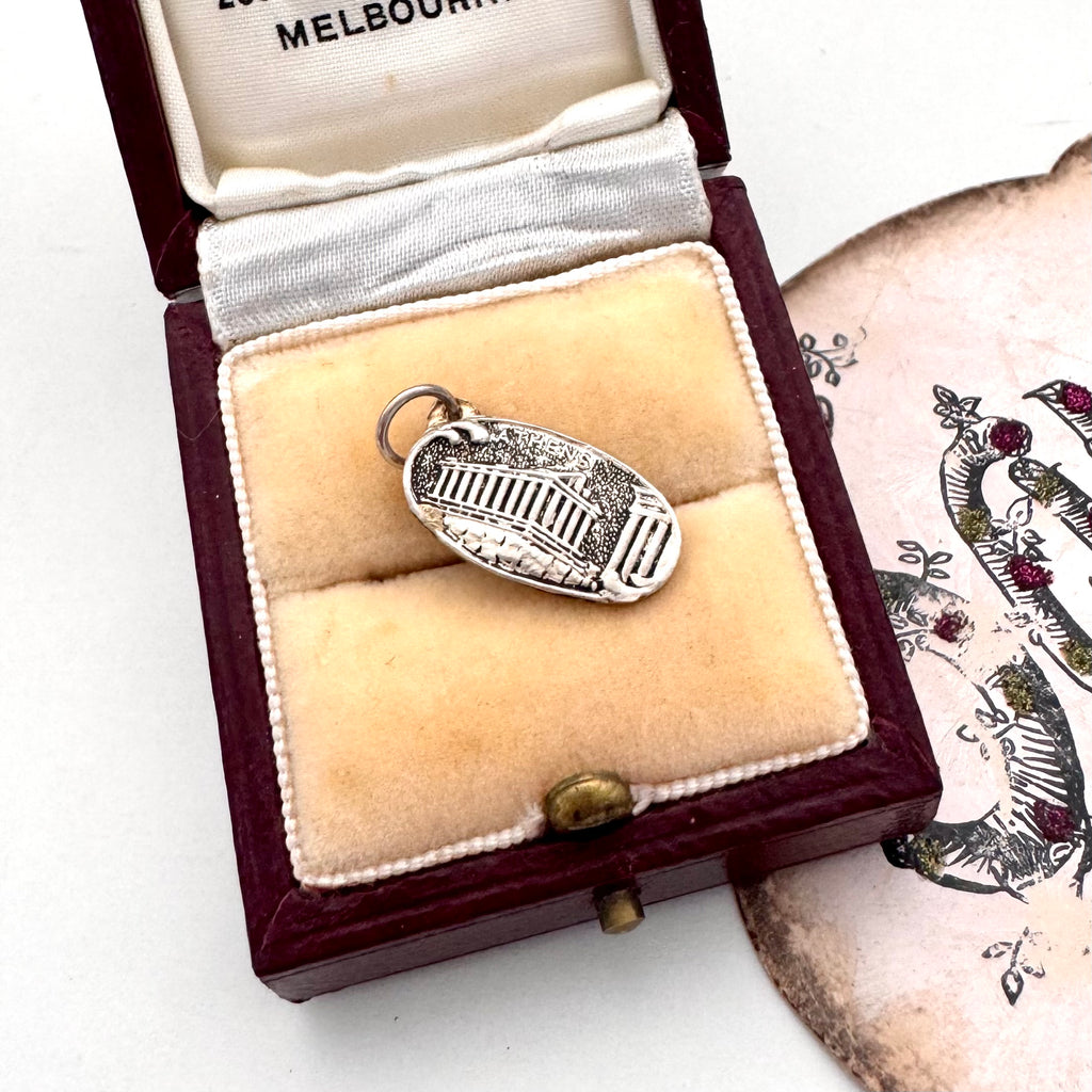 Vintage silver Parthenon charm in a jewelry box with a white background