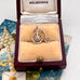 Silver bicycle charm in a jewelry box with 'Melbourne' branding on a decorative background.