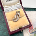 Silver seahorse charm in an open jewelry box with a decorative background