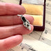 Silver shoe charm held between fingers on a sheet of music