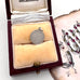 Silver pendant in a jewelry box with a decorative card in the background