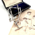 Silver chain necklace in an open box with vintage photo of three women.