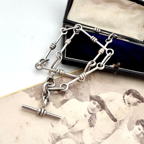 Vintage trombone silver chain necklace on an old photograph with a vintage box in the background