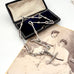 Vintage silver trombone chain in an open box with an old photograph of two women in the background.