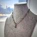 Necklace on a mannequin bust with a blurred outdoor background