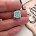 Small silver and enamel 'Weymouth' pendant held between fingers 