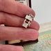 Vintage silver wishing well charm in someone's hand