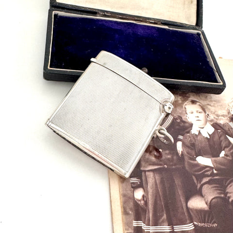 Vintage 1935 hallmarked vesta case made by G&SC Ltd of Regent St, London with a black box and vintage photo of children on a white background