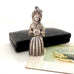 Vintage figural sterling silver needle cae necklace on an old jewellery box and with a vintage postcard