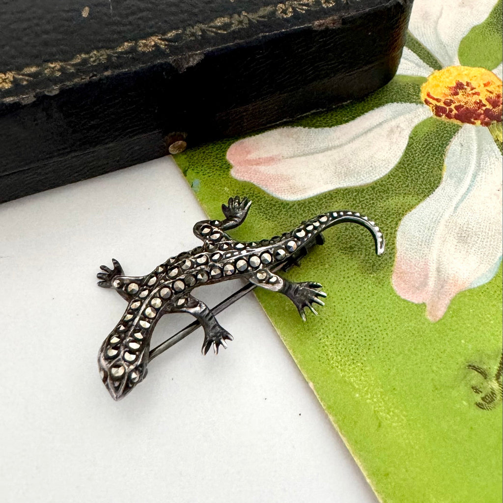 Vintage sterling silver marcasite lizard brooch on a floral background
