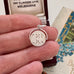 Vintage silver spinning "Good Luck" charm in a woman's hand