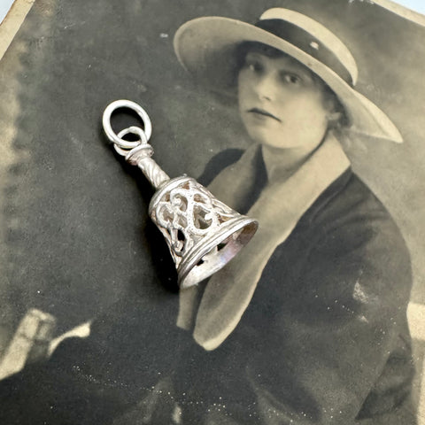 Vintage photograph of a woman with a decorative silver bell pendant overlay
