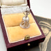 Vintage sterling silver charm in a box with a vintage photo in the background