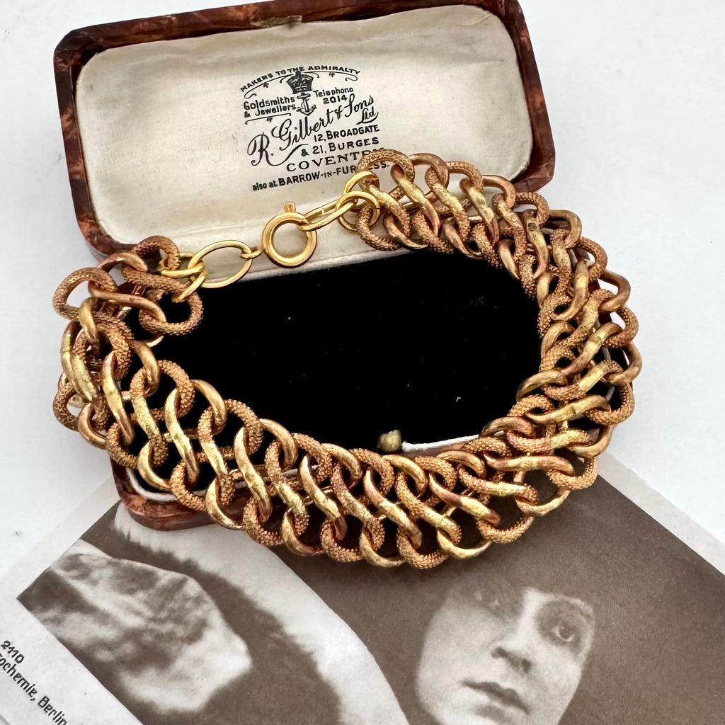A vintage chunky gold chain bracelet with a lobster clasp, displayed inside its vintage brown presentation box. The box lid features a cream-colored interior printed with the brand name 'R.