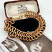 A vintage chunky gold chain bracelet with a lobster clasp, displayed inside its vintage brown presentation box. The box lid features a cream-colored interior printed with the brand name 'R.