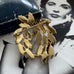 Gold brooch with leaf design on a black and white background