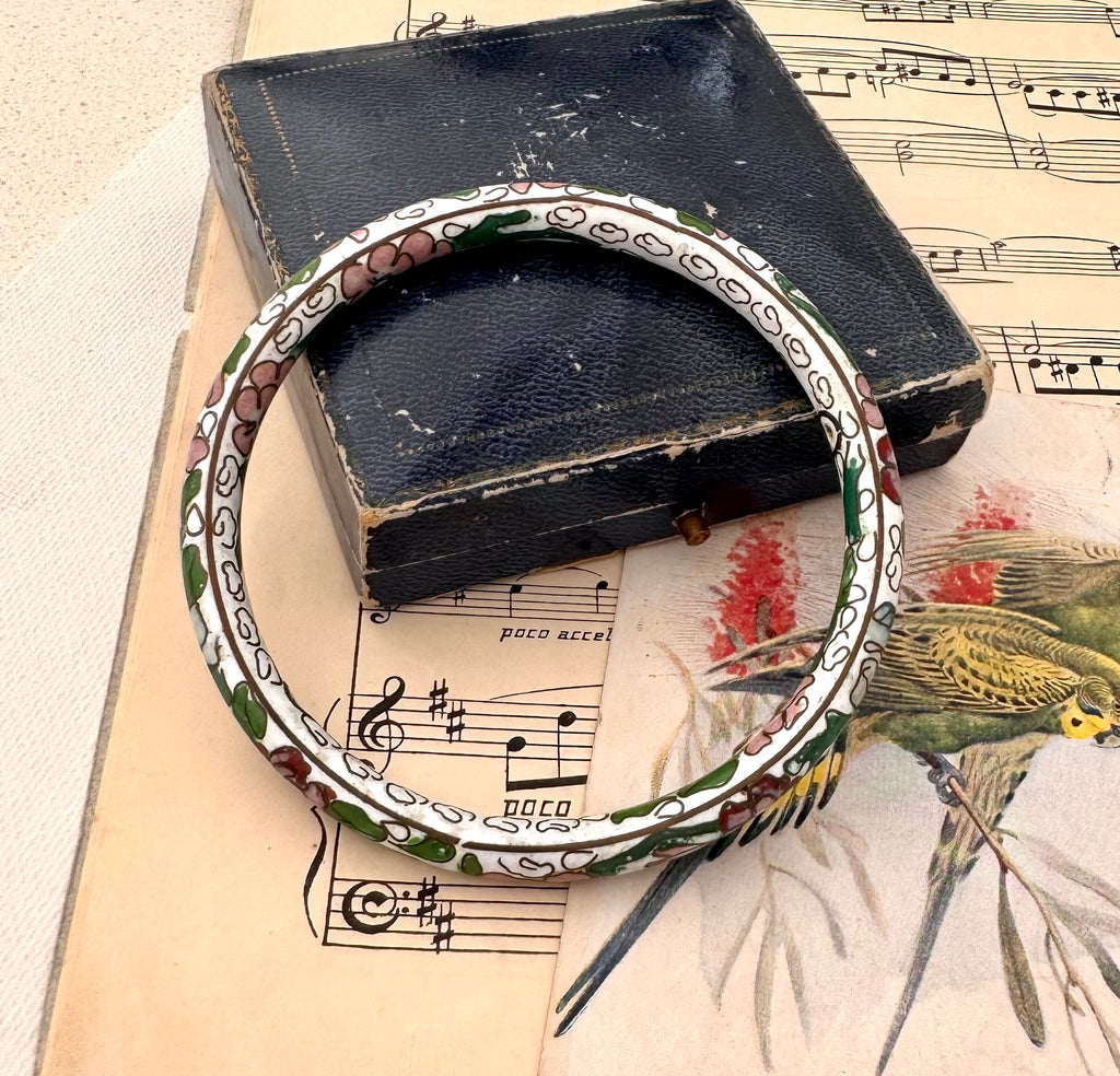 Vintage cloisonne bracelet on a vintage box with music sheet background