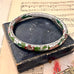 Vintage cloisonne bracelet on a vintage box with music sheet background