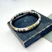 Vintage white cloisonne hinged bangle on an old jewellery box