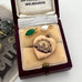 Vintage WW2 heart-shaped brooch with green stone and pearl charms  in a jewelry box labeled 'Melbourne'.
