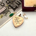 Vintage WW2 heart-shaped vintage pendant with engraved text on a white surface