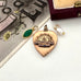 Vintage ww2 Australian eart-shaped pendant with engraved design on a white surface