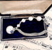 Vonk Jewellery 1905 threepence, pearl and sterling silver bracelet on a music manuscript and a vintage jewellery box