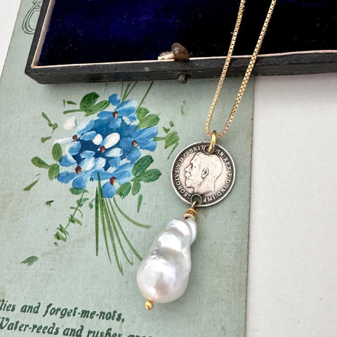 Vonk Jewellery 1915 silver threepence and baroque pearl necklace on a vintage jewellery box and vintage postcard