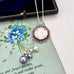 Vonk Jewellery 1918 silver threepence and pearl drop necklace on a vintage postcard and vintage jewellery box