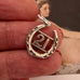 Vonk Jewellery 1963 hallmarked lucky horseshoe charm on an Ingres painting of a woman and in a womans hand