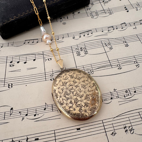 Vonk Jewellery vintage 1970 22ct gold plated locket necklace on a vintage jewellery box and music manuscript