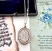 Vonk Jewellery 1876 sterling silver locket necklace on a vintage postcard and vintage jewellery box