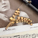 Back of Vonk Jewellery antique art nouveau rhinestone spray brooch on a vintage postcard and with a vintage jewellery box