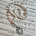 Vonk Jewellery antique watch fob pearl long necklace on a vintage sheet music