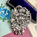 Back of Vonk Jewellery large vintage marcasite and pink rhinestone brooch on a vintage postcard and with a vintage jewellery box