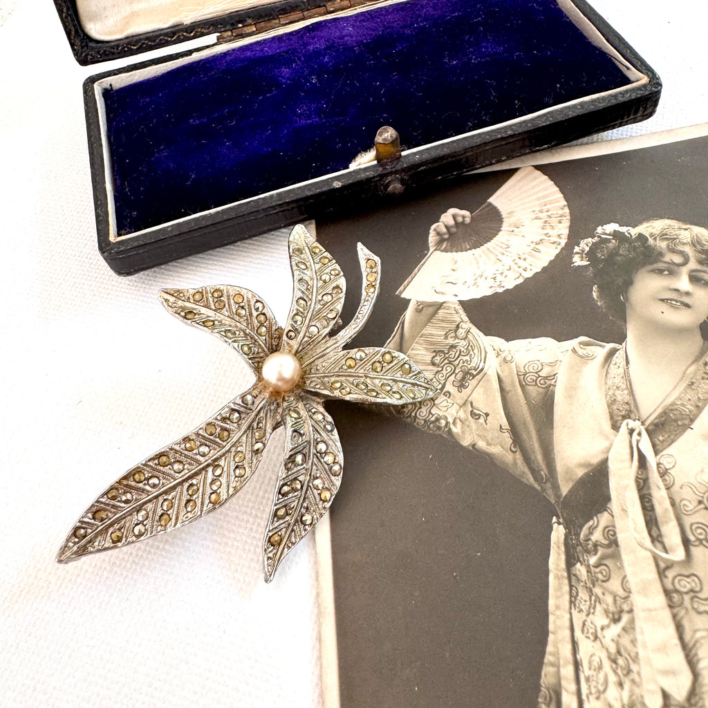 Vonk Jewellery vintage rhodium plated marcasite flower brooch with a vintage jewellery box and vintage postcard