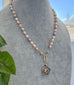 Vonk Jewellery pale pink pearl and vintage watch fob necklace on a pale grey jewellery display