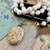 Vonk Jewellery rolled gold vintage locket and pearl necklace on a vintage jewellery box and vintage postcards