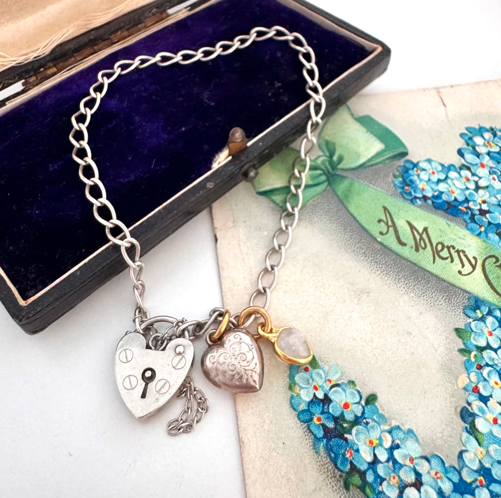 Vonk Jewellery vintage sterling silver heart clasp bracelet with a vintage charm and moonstone charm on a vintage postcard and jewellery box