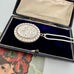 Vonk Jewellery 1977 sterling silver engraved locket on a vintage jewellery box and with a card of a woman with red flowers in her hair