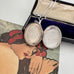 Vonk Jewellery 1977 sterling silver engraved locket on a vintage jewellery box and with a card of a woman with red flowers in her hair