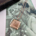 Vonk Jewellery vintage rolled rose gold square locket necklace on a vintage postcard