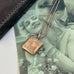 Vonk Jewellery vintage rolled rose gold square locket necklace on a vintage postcard