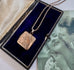 Vonk Jewellery vintage rolled rose gold square locket necklace on a vintage postcard