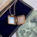 Vonk Jewellery vintage rolled rose gold square locket necklace on a vintage postcard