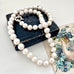 Pearl necklace draped over a vintage book with floral bookmark
